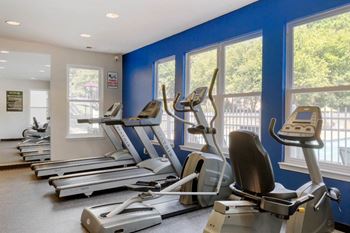 Fitness center with exercise equipment in front of window